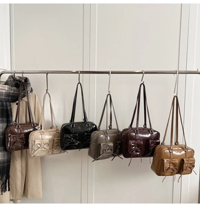Row of vintage faux leather shoulder bags in six colors with bow-tie pocket details