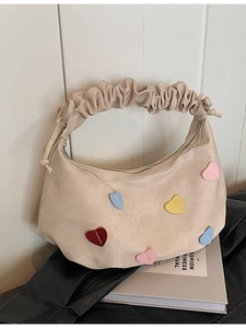 Off-white canvas hobo bag with colorful heart patches and stylish ruched handle
