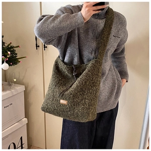 Détail du sac fourre-tout en peluche vert forêt avec tissu texturé et étiquette logo