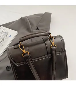 Close-up of premium gold-tone metal hardware on a dark brown vintage leather tote bag