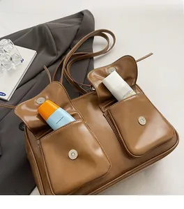 Detail view of vintage brown leather bag featuring two front magnetic flap pockets