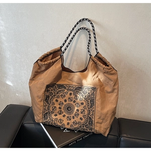 Close-up of vintage paisley tote with woven rope handles and drawstring detail