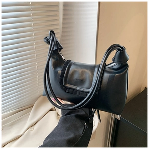 Detail of black crossbody bag featuring pleated edge flap and knotted rope shoulder strap