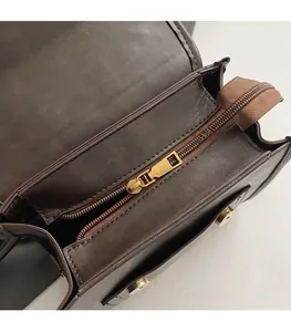 Detail of smooth metal zipper and magnetic buckle on vintage brown leather backpack