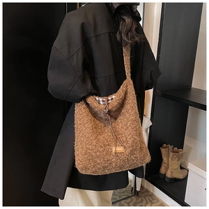 Gros plan du sac cabas en peluche marron montrant la texture bouclée et le cordon