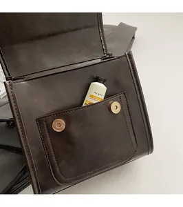 Close-up of vintage dark brown backpack showing the practical front magnetic pocket