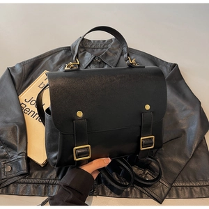 Detailed view of the vintage black leather backpack featuring gold buckles and studs