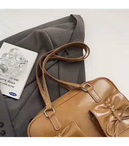 Close-up of vintage brown PU leather bag with decorative bow and smooth comfortable straps