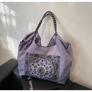 Detail of vintage paisley tote bag featuring drawstring closure and woven rope handles