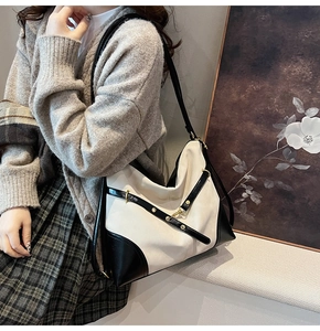 Detail of classic black and white contrast tote bag with metal rivets and buckle