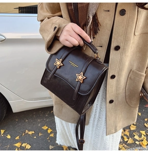 Detail of vintage brown PU leather bag with gold star buckles and fashion logo lettering