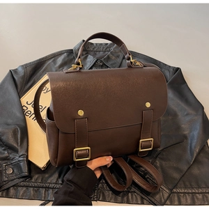 Close-up of vintage brown leather backpack with gold rivets and buckle flap detail