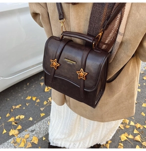 Detail of dark brown vintage mini backpack with gold star rivets and adjustable straps