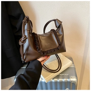 Detail of dark brown dumpling bag with knotted handle and ruffled edge design