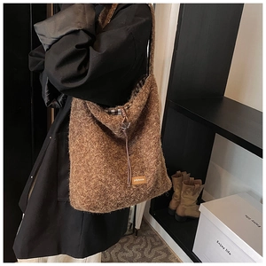 Détail du sac cabas marron avec logo en cuir et doublure à carreaux noirs et blancs