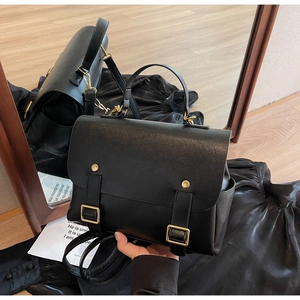 Detailed view of black vintage leather backpack with gold buckles and dual-use straps