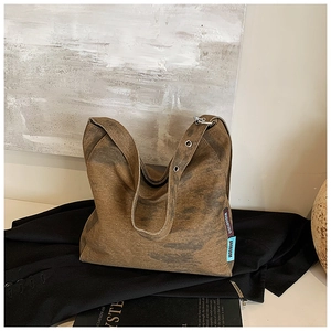 Detailed view of vintage washed canvas tote bag texture with brand label and metal buckle