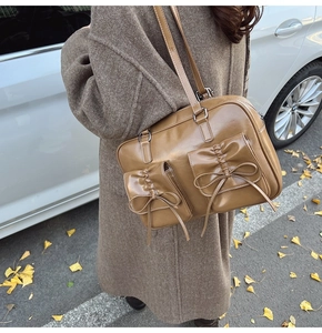 Detail of vintage brown leather bag with bow pockets in an autumn street setting