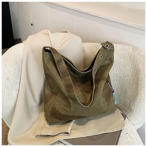 Close-up of olive green vintage canvas tote bag with adjustable metal eyelet strap