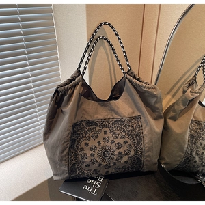 Detail of paisley print tote bag featuring drawstring closure and woven rope handle