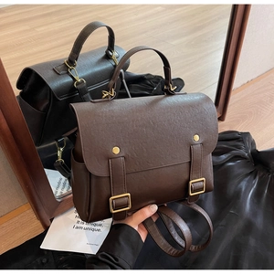 Detail view of vintage dark brown faux leather backpack with metallic buckles and top handle