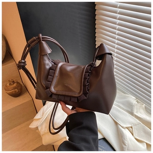Detail of dark brown retro crossbody bag with ruffled edges and matte leather finish