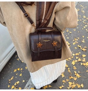 Brown vintage leather crossbody bag with star buckles and autumn fashion styling