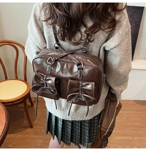 Detail view of deep brown vintage backpack with bow accents in a cozy indoor setting
