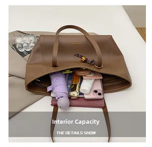 Vista dall'alto degli interni spaziosi della borsa tote in pelle marrone con vari accessori
