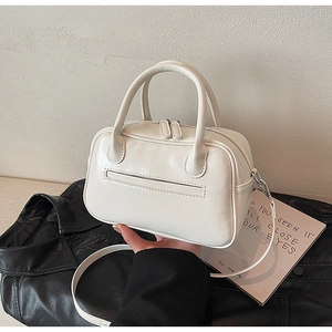 Detailed view of a white Boston handbag with dual handles and detachable shoulder strap