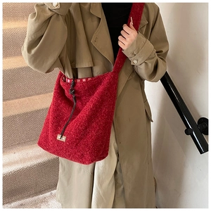 Gros plan d'un sac cabas en polaire rouge avec logo en cuir et doublure vichy