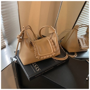 Detail of caramel faux leather bag with ruffled edge and Ruankou brand embossing