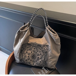 Detail of taupe fabric tote bag featuring vintage paisley prints and woven rope handles