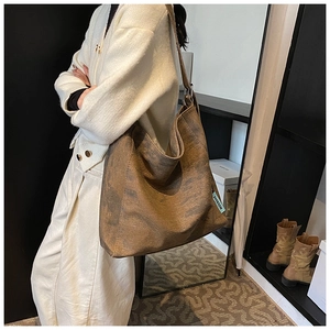 Detail of vintage brown canvas hobo bag showing retro washed texture and brand woven label