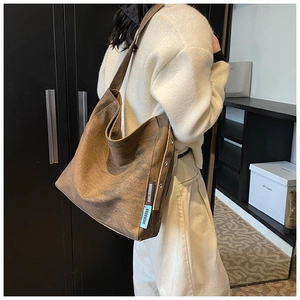 Detail view of brown canvas tote bag with woven logo straps and vintage metal eyelets