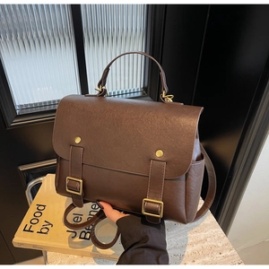 Detailed view of dark brown vintage matte leather backpack with metallic buckle accents