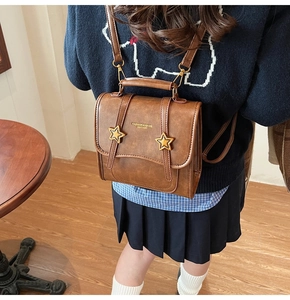 Rear view of vintage brown leather backpack with yellow stars and strap details