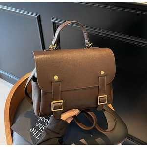 Detail of vintage dark brown backpack with golden buckles and premium leather texture