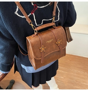 Detail of vintage brown leather backpack with gold star accents and adjustable straps