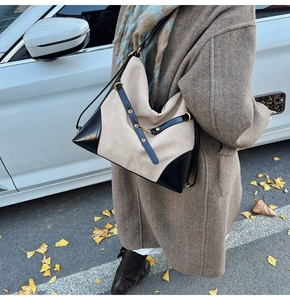 Chic beige and black tote bag with gold hardware shown in a street style autumn setting