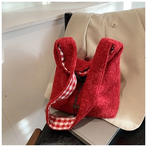 Détail du sac cabas en peluche rouge avec doublure vichy et écusson en cuir
