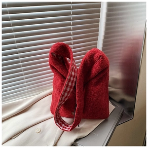 Détail du sac cabas en polaire rouge avec doublure de bandoulière à carreaux rouges