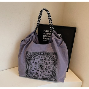 Detail of lavender tote bag with black and white mandala print and braided handles