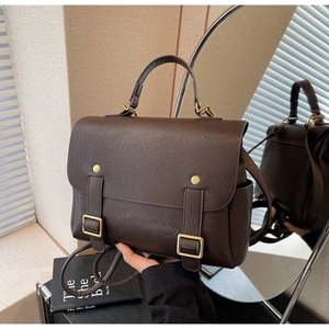 Detail view of the vintage dark brown backpack with gold buckles and dual straps