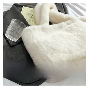Gros plan sur la texture en fausse fourrure blanche et l'anse du sac fourre-tout
