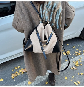 Detail of minimalist bicolor tote featuring cream suede texture and black leather strap