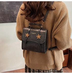 Rear view of a model wearing the black vintage star backpack with gold star buckles