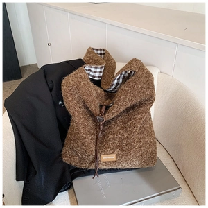 Gros plan du sac fourre-tout en polaire marron avec doublure à carreaux et cordon