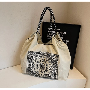 Close-up of ethnic paisley canvas tote bag with woven handles and drawstring detail
