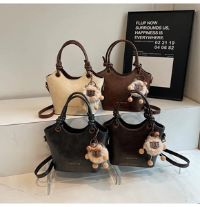 Detailed view of matte leather bucket bags in four colors with plush sheep charms